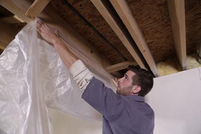 Crew Installing basement waterproofing vapor barrier