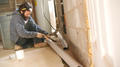 Crew cutting BasementGutter during installation