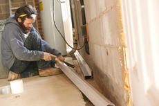 Crew cutting BasementGutter during installation
