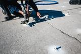 Crew installing PolyRenewal on driveway