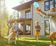 Family outside with dog playing Frisby.