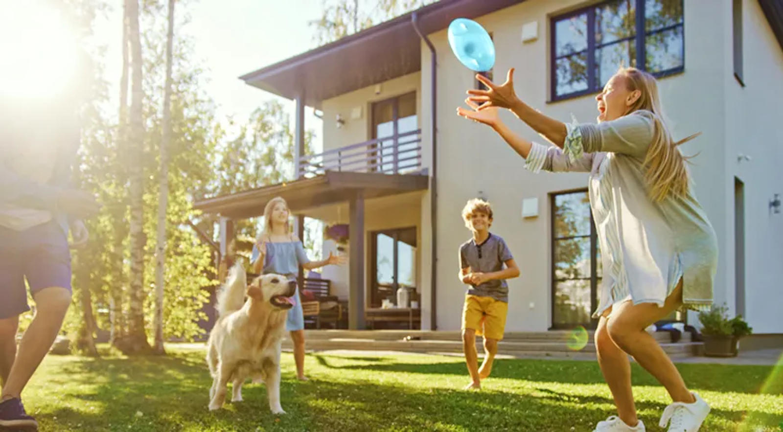 Family outside with dog playing Frisby.