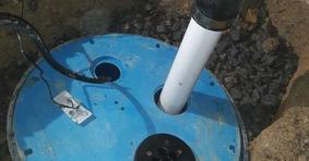 The top of the sump pump and drain line in basement.
