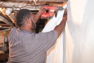 Crew drilling wall seal on the interior basement wall.