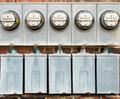 Five electrical meters on the exterior brick wall.