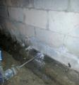 Drill drilling weep holes in the cinderblock basement.