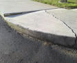 Cracked and uneven sidewalk and curb.