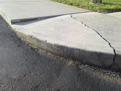 Cracked and uneven sidewalk and curb.