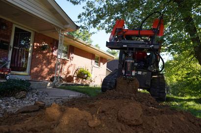 Crew plowing soil in the front yard.