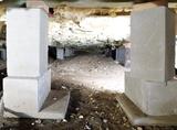 Concrete blocks support Colorado foundations in a crawl space with exposed soil and insulation above.