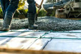 Close-up of crew shoveling poured cement.