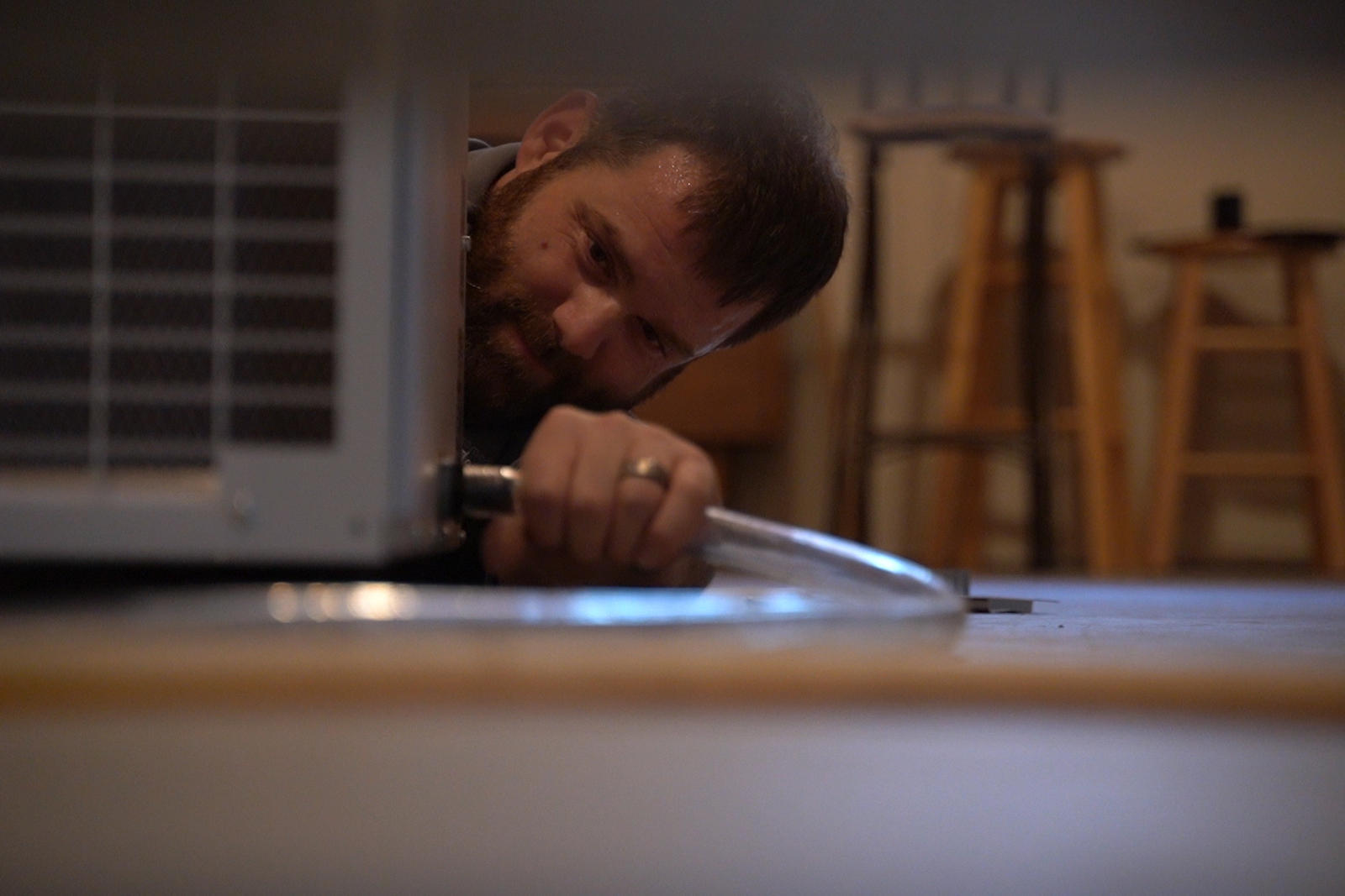 Technician installing dehumidifier hose in basement