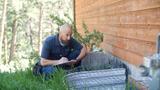 Groundworks inspector evaluates exterior foundation wall and egress.