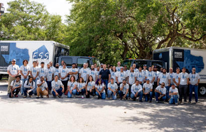 FSS staff shot outside in front of supply trucks.