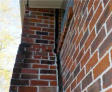 Chimney separating from the brick exterior foundation wall.
