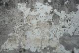 A close-up of an old, weathered wall with peeling paint and patches of exposed surface.