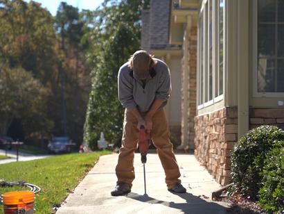 Crew drilling through sidewalk