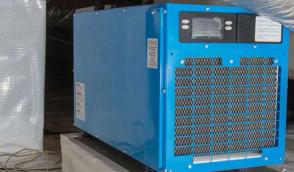 A blue industrial dehumidifier placed on a black platform.