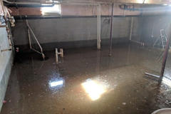 Flooding basement with sump pump covered by standing water.