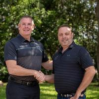 Mr. Holt and Mr. Malone shake hands.