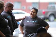 Staff smiling with their #wintogether shirts.