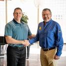 Ted Munkres and Matt Malone are shaking hands.