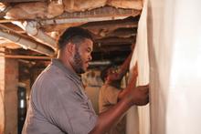 Crew installing vapor barrier in the basement