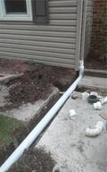A downspout line being installed into the ground.