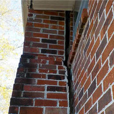 Brick chimney separating from the foundation wall.