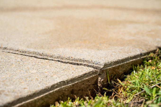 A close-up of an uneven sidewalk.