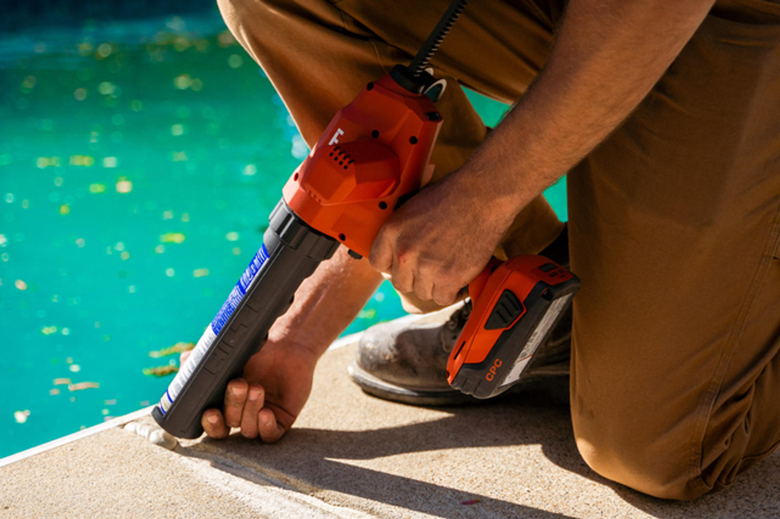 Crew's hand is injecting poly into the pool deck.