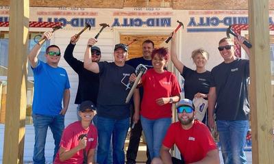 Goodworks committee at project site holding hammers and smiling.