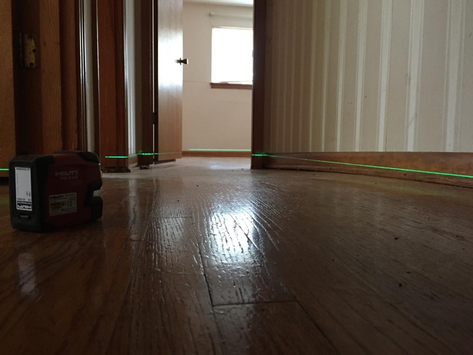 Laser level inspection on the uneven interior floor.
