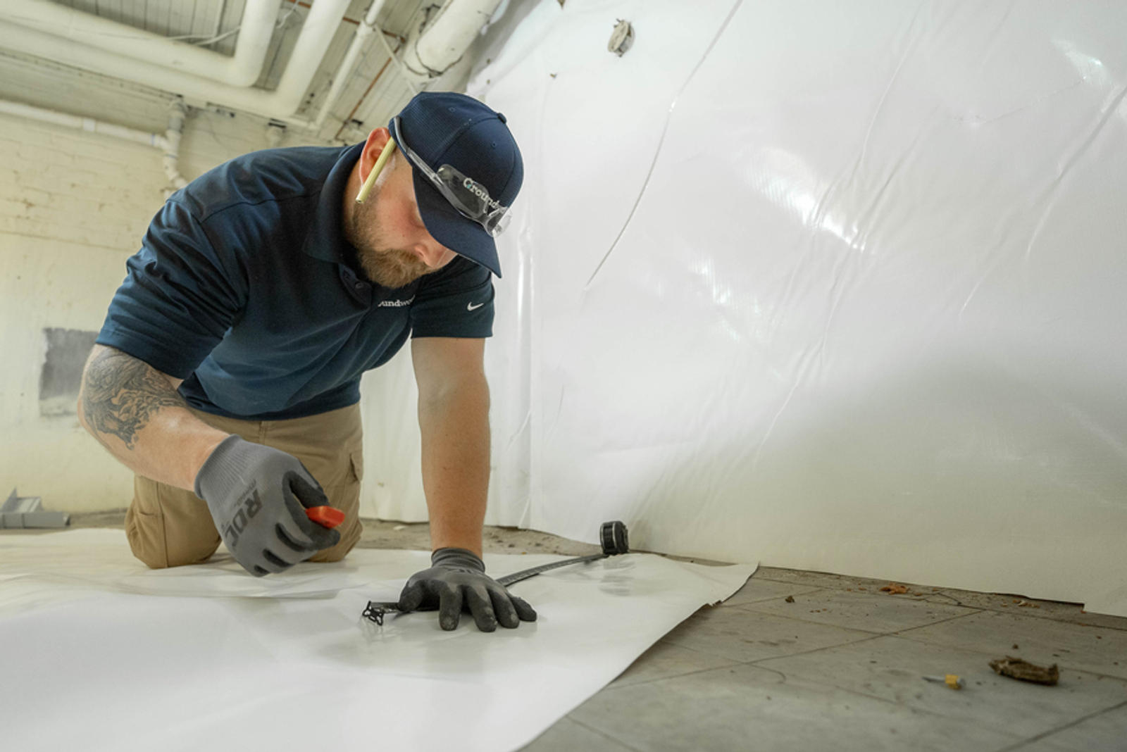 Groundworks employee encapsulating with vapor barrier