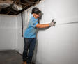 Groundworks worker installing basement vapor barrier