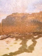 A textured wall with brown and orange hues, resembling a landscape scene with water reflections on sand.