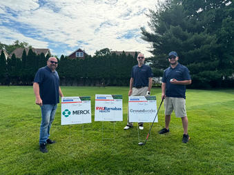 Groundworks staff pose with sponsor lawn signs