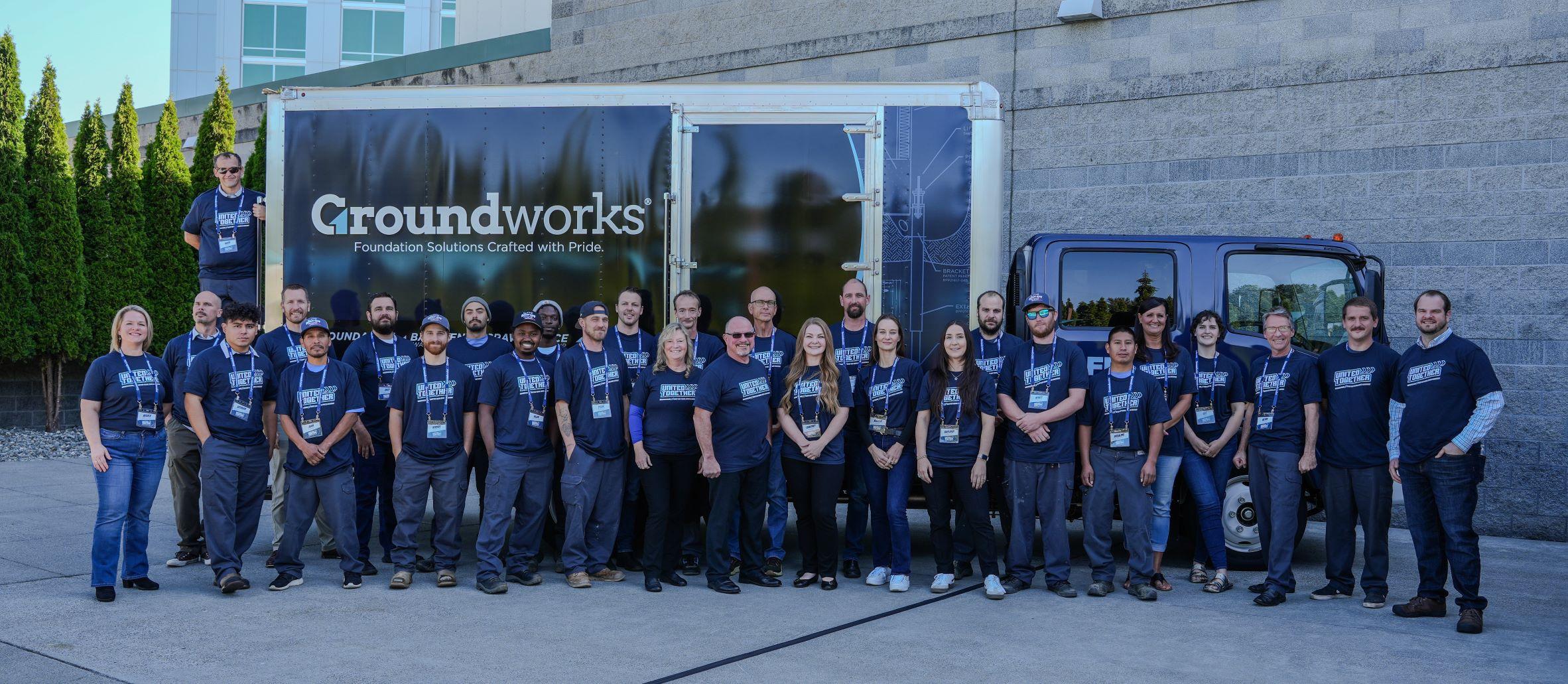 Outside by a branded truck, the Groundworks team poses for a photo, their matching shirts reflecting unity and dedication. This moment captures the spirit of Groundworks Northwest Washington.