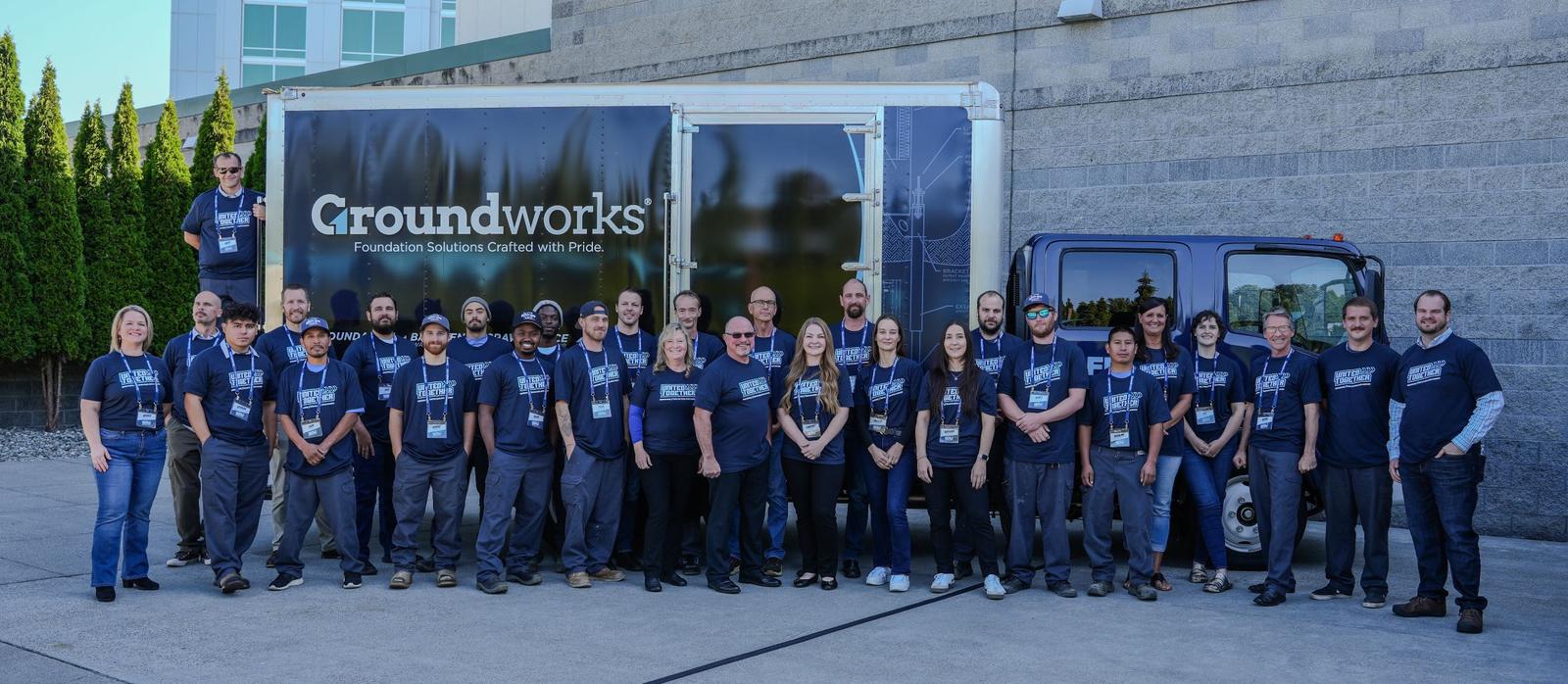 Outside by a branded truck, the Groundworks team poses for a photo, their matching shirts reflecting unity and dedication. This moment captures the spirit of Groundworks Northwest Washington.