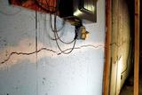 Large horizontal crack runs along a basement wall—with electrical wires and an outlet above it.