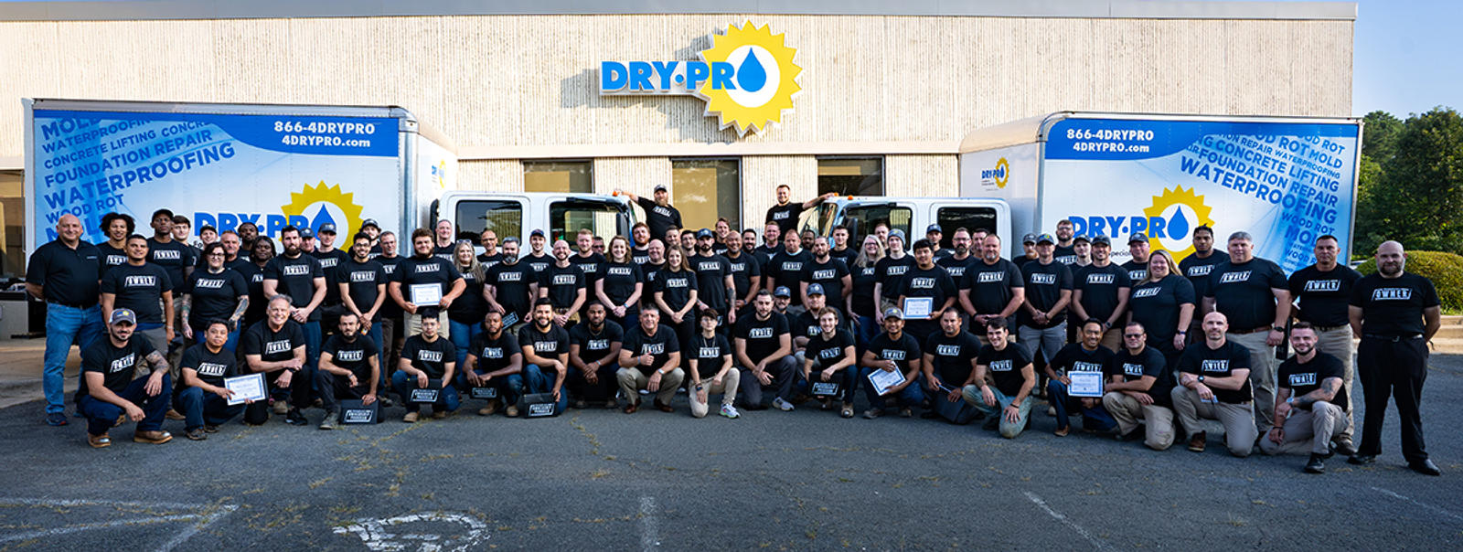 Dry Pro Foundation and Crawlspace Specialists Employees standing in front of Dry Pro Building and box trucks.