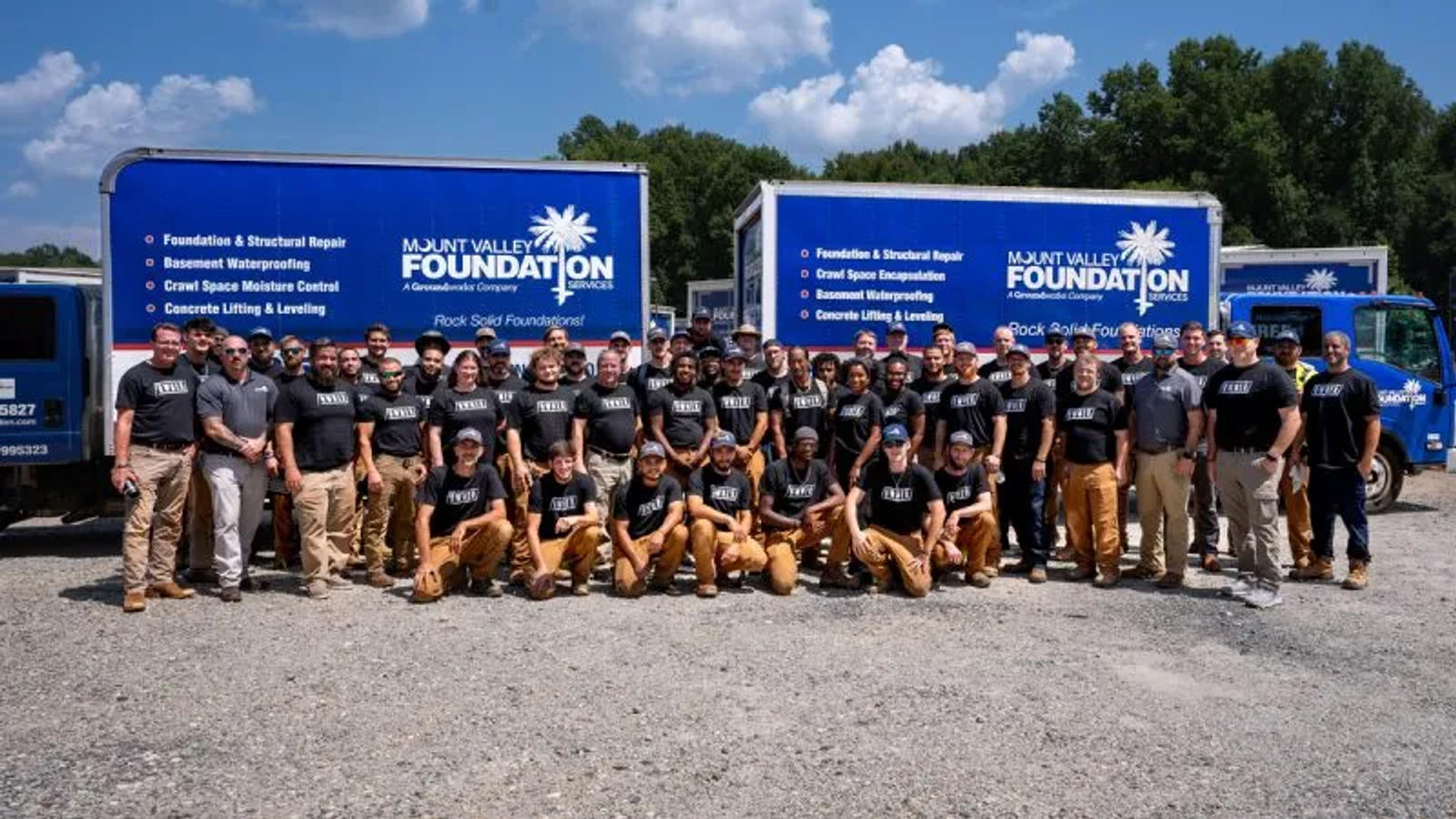 MVFS staff at Ownership Tour with supply trucks in the background.