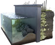 Cross-section of a concrete water barrier with visible rocks and soil layers, providing foundation support for new builds.