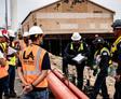 Team of workers discuss a fix to a seawall at a port