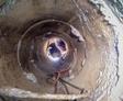 View from a pipe shows a person peering in, with visible ropes, reminiscent of a Rancho Cucamonga case study scene.