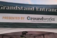 Sign reading "Grandstand Entrance" presented by Groundworks, with the tagline "Foundation Solutions Crafted with Pride.