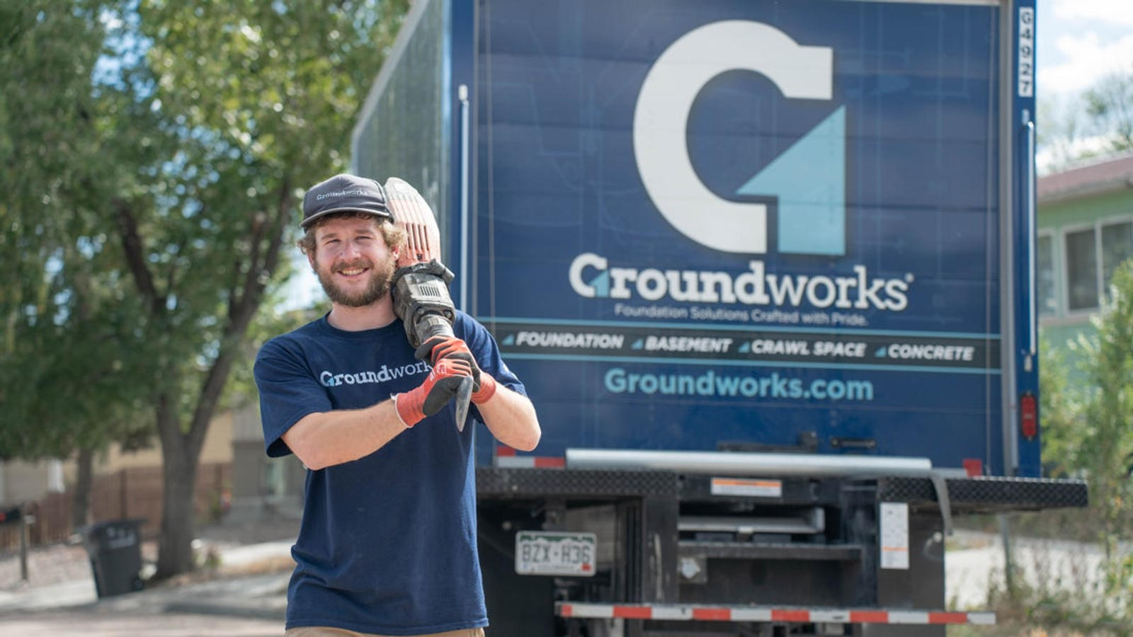 GW employee working hard near a Groundwork work truck
