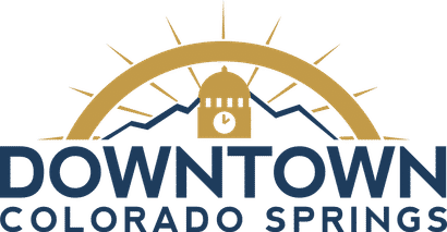 Logo of Downtown Colorado Springs with a clock tower and mountain design.