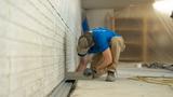 worker installing basement drainage