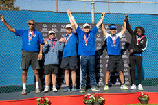 Athletes celebrate on a podium wearing medals, with hands raised; a Special Olympics banner is in the background.